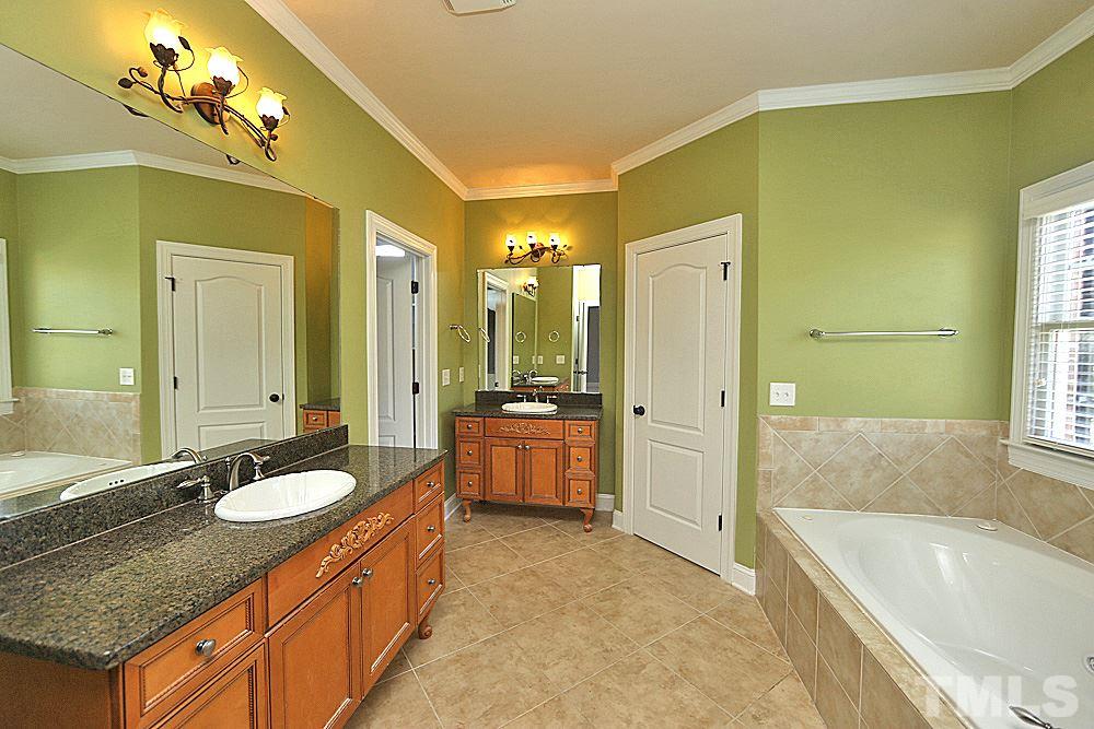 5214 Landguard Drive Raleigh, NC 27613 - Photo 13 of 20 a bathroom with a granite countertop tub sink and mirror