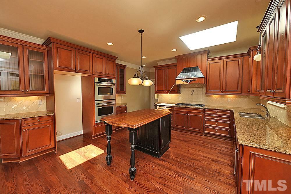5214 Landguard Drive Raleigh, NC 27613 - Photo 7 of 20 a kitchen with stainless steel appliances granite countertop a refrigerator a sink dishwasher a stove and a oven with wooden floor