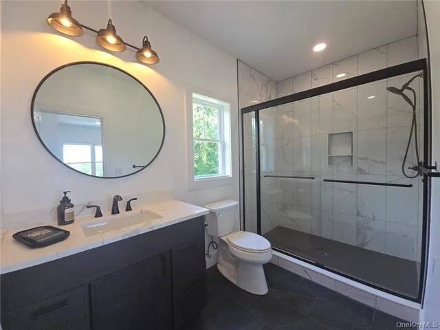 a bathroom with a sink a toilet and a mirror