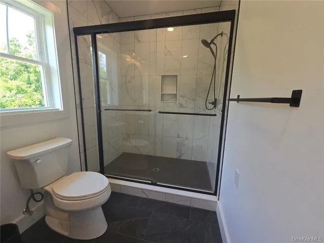 a bathroom with a toilet and a shower