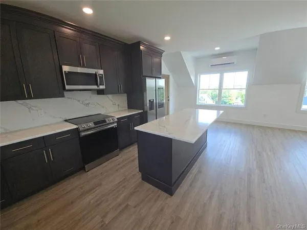 a kitchen with stainless steel appliances granite countertop a stove a sink and a microwave