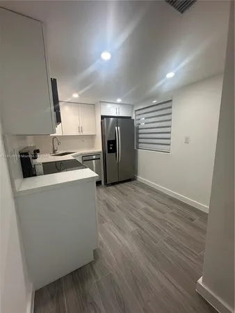 a view of a kitchen with a sink and a refrigerator