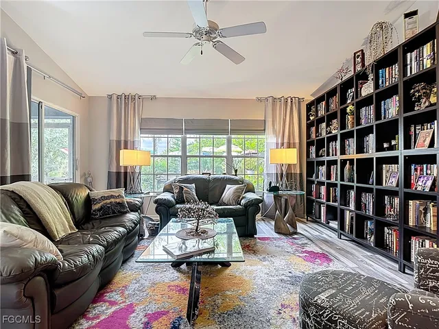 a living room with furniture a rug and a book shelf
