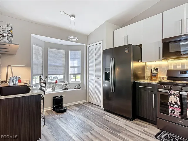 a kitchen with stainless steel appliances a refrigerator a sink a stove and cabinets