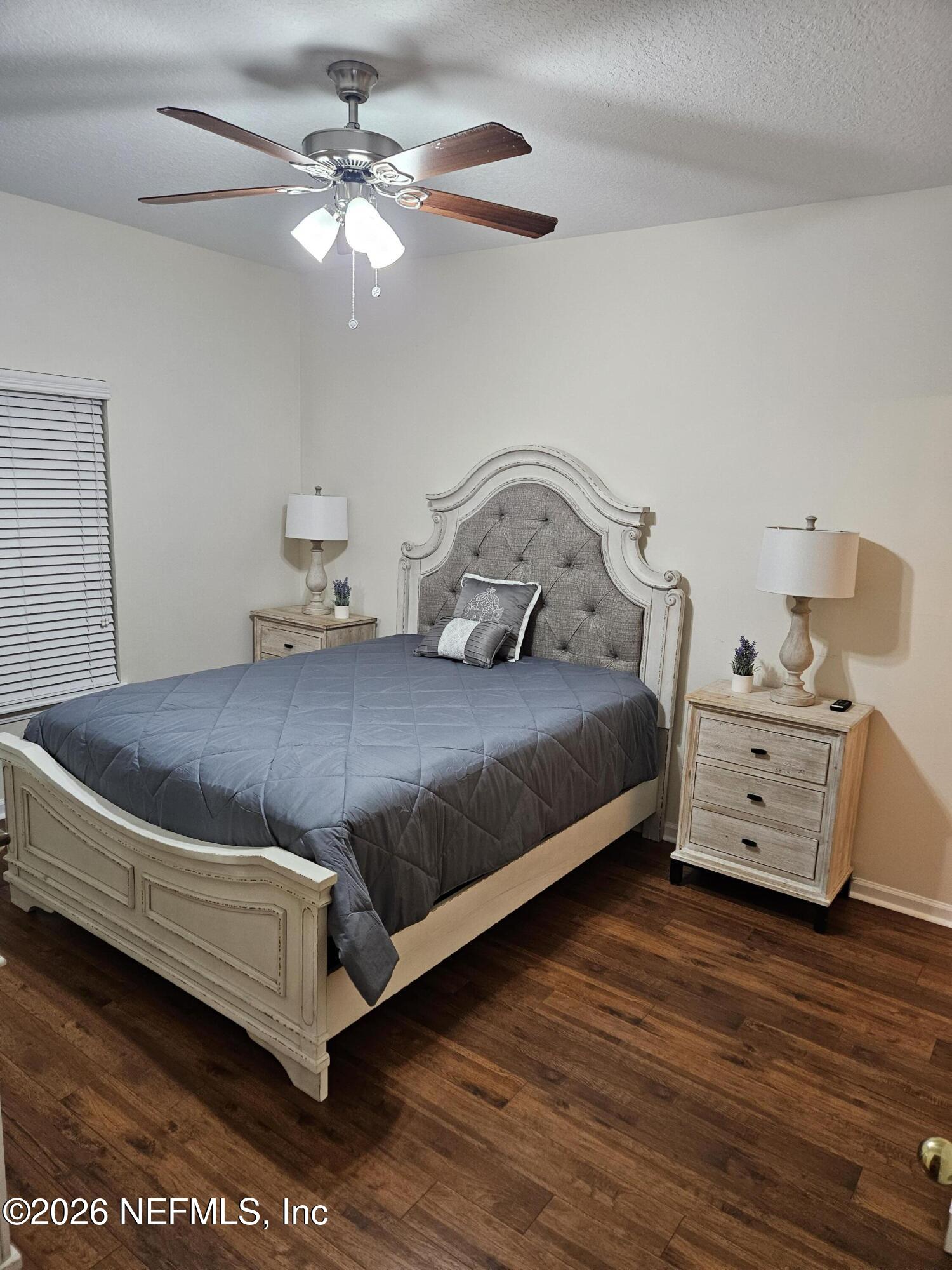 8218 Green Parrot Road, Unit 308 Jacksonville, FL 32256 - Photo 13 of 27 a bedroom with a bed and wooden floor