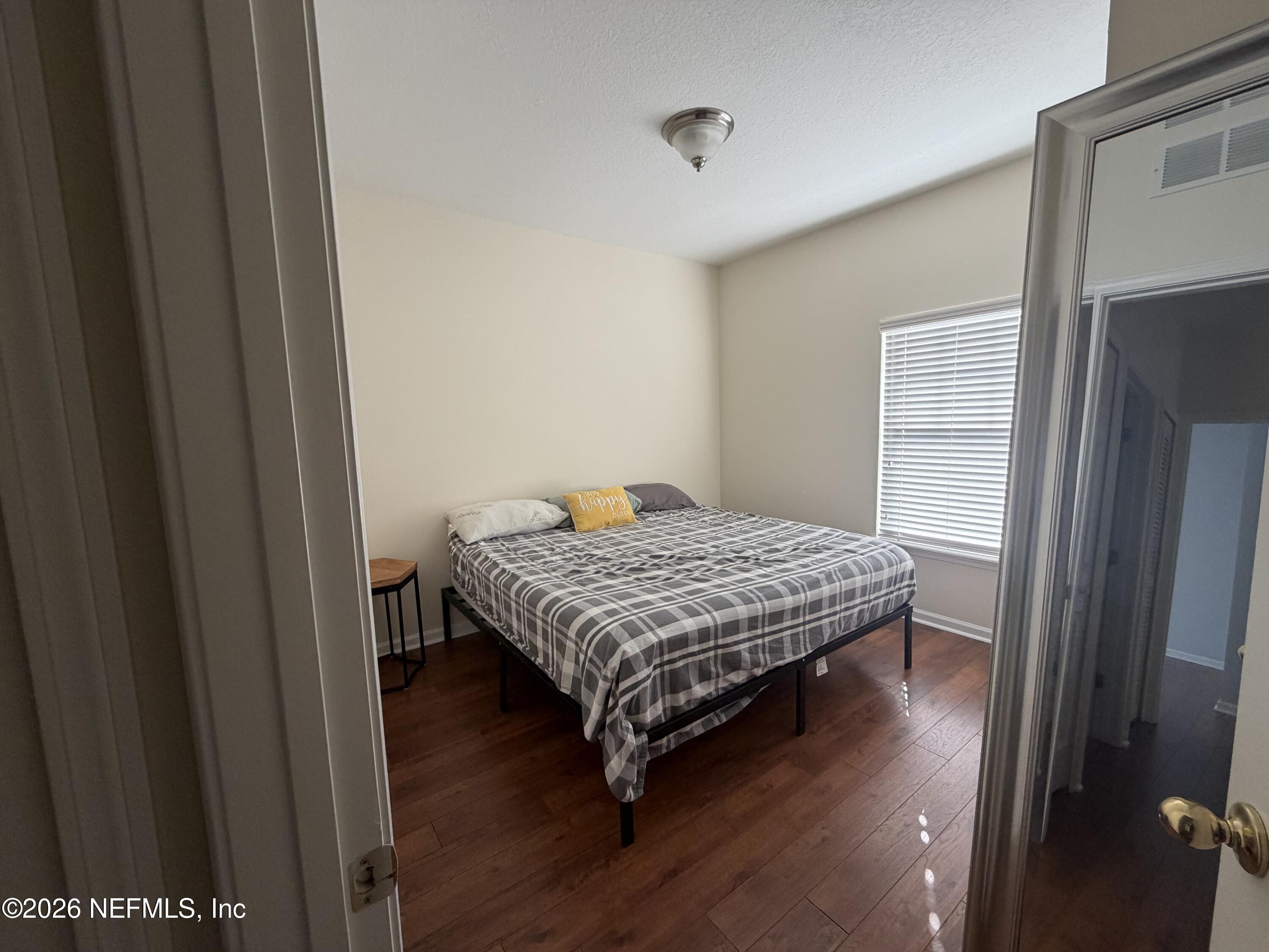 8218 Green Parrot Road, Unit 308 Jacksonville, FL 32256 - Photo 8 of 27 a bedroom with a bed and wooden floor