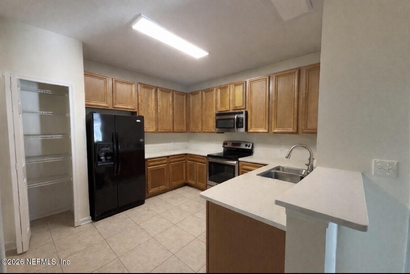 8218 Green Parrot Road, Unit 308 Jacksonville, FL 32256 - Photo 9 of 25 a kitchen with a refrigerator sink and cabinets