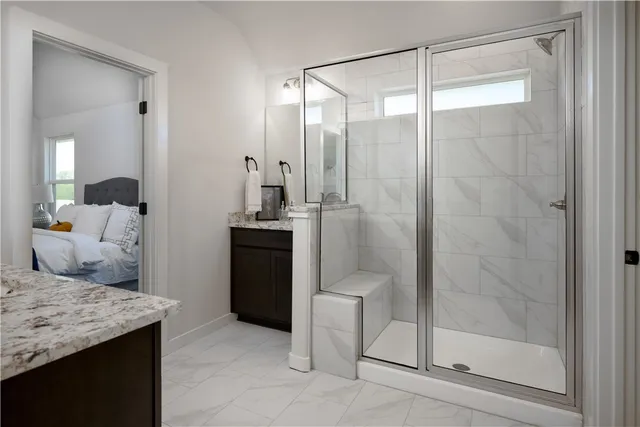 a bathroom with a granite countertop sink a toilet and shower