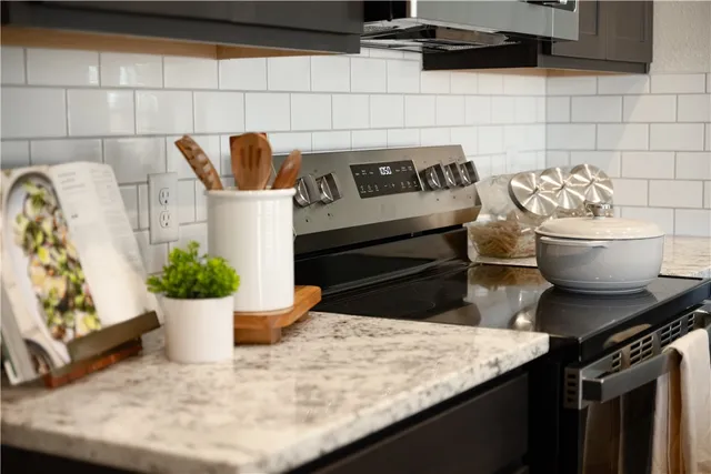 a kitchen with a stove and white cabinets