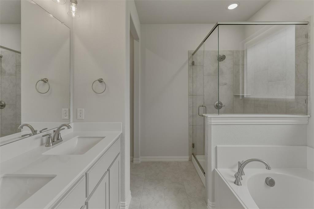 156 Oak Grv Way Springtown, TX 76082 - Photo 18 of 25 Bathroom featuring a double vanity with integrated sinks, a walk-in shower with clear glass enclosure and tiled walls, a built-in soaking tub, and contemporary brushed nickel fixtures
