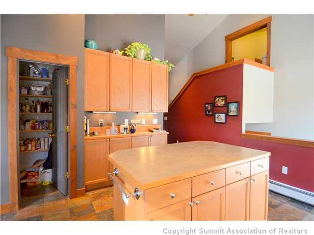 414 Big Elk Road Dillon, CO 80435 - Photo 16 of 25 a kitchen with a refrigerator a stove and a dining table with wooden floor