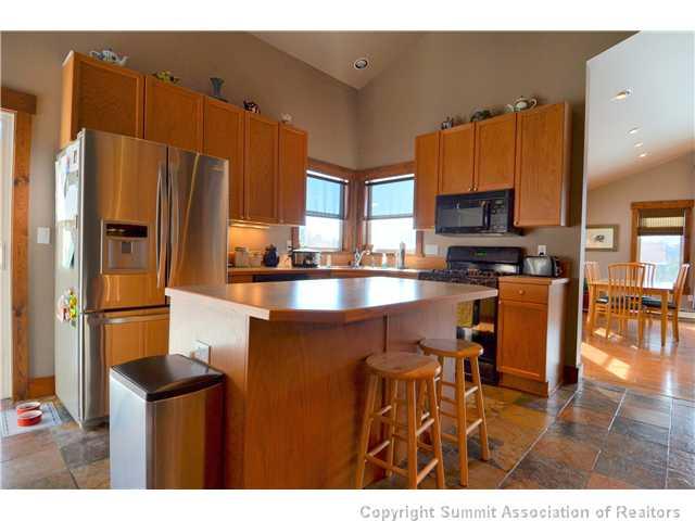 414 Big Elk Road Dillon, CO 80435 - Photo 3 of 25 a kitchen with stainless steel appliances a refrigerator a stove a sink a dining table and chairs