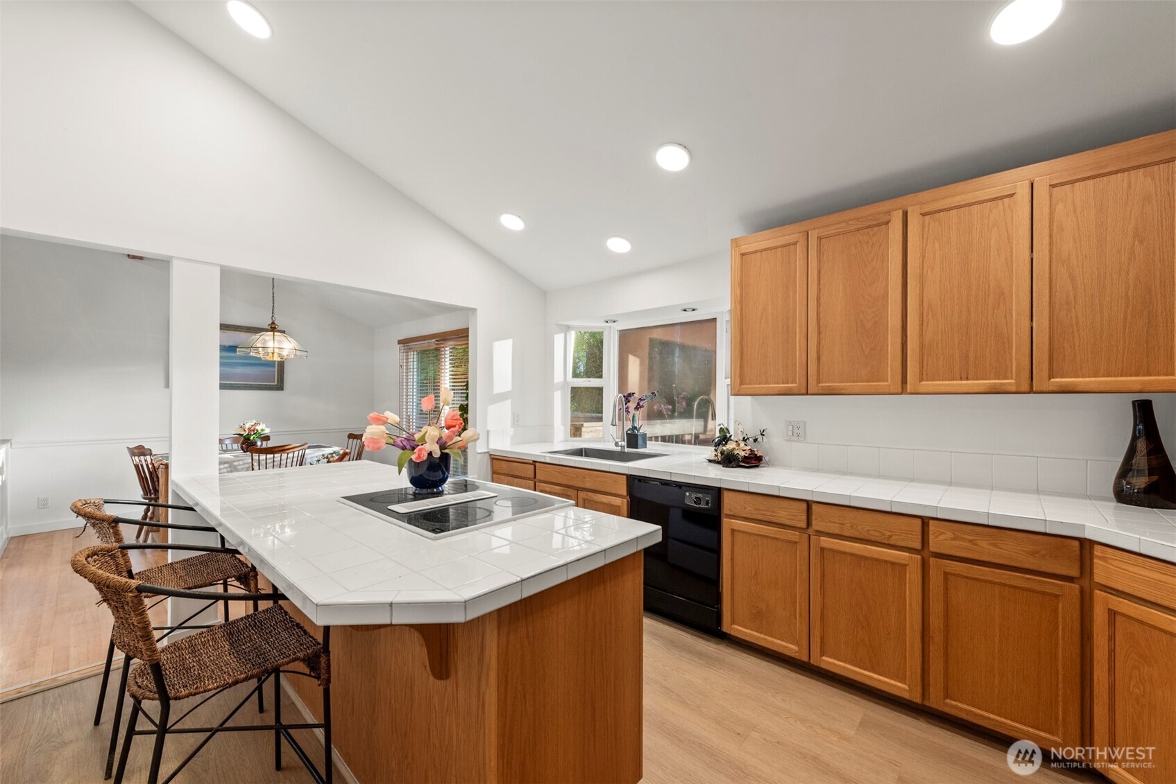 13405 Southeast 56th Place Bellevue, WA 98006 - Photo 13 of 38 a kitchen with kitchen island granite countertop a sink cabinets and wooden floor