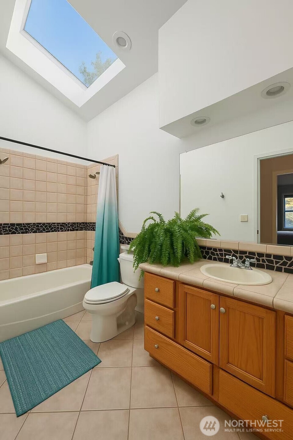 13405 Southeast 56th Place Bellevue, WA 98006 - Photo 19 of 38 a bathroom with a sink a toilet a mirror a vanity and bathtub