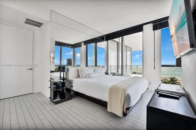 a bedroom with a bed and a large window