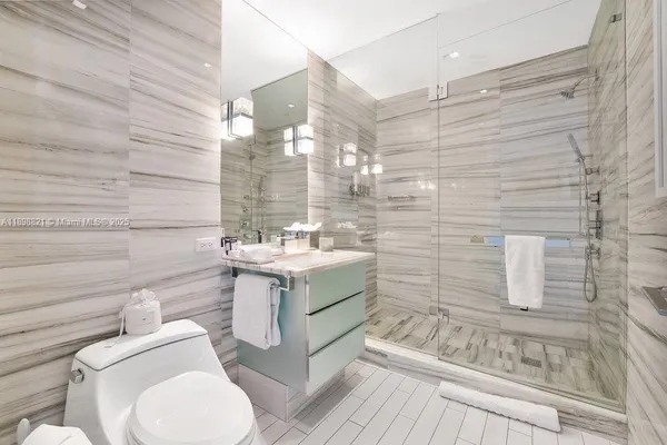 a bathroom with a granite countertop toilet sink and mirror
