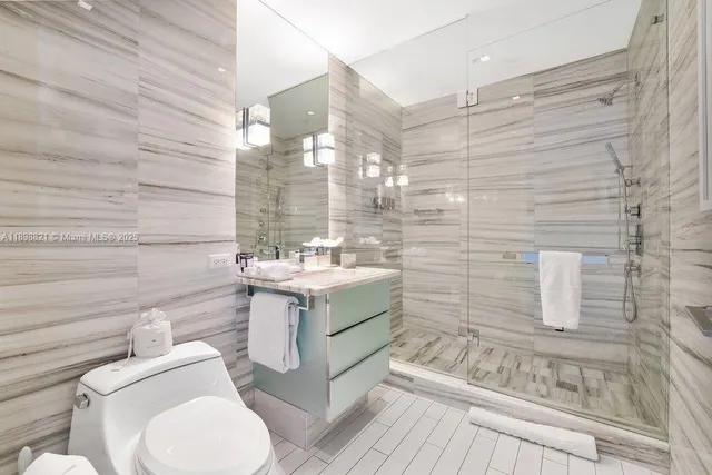 a bathroom with a granite countertop toilet sink and mirror