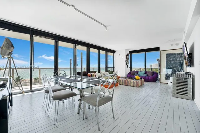 a living room with furniture floor to ceiling window and wooden floor