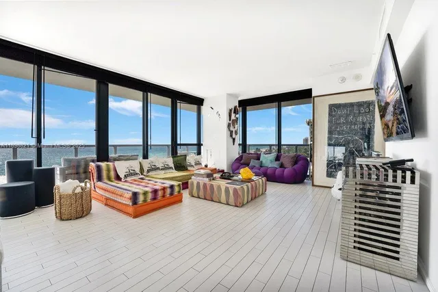a living room with furniture and large windows