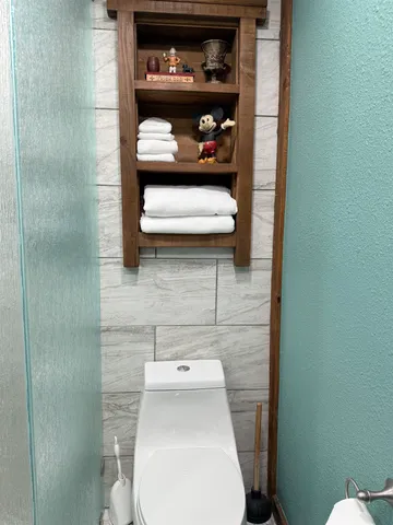 a white toilet sitting next to a bathroom sink