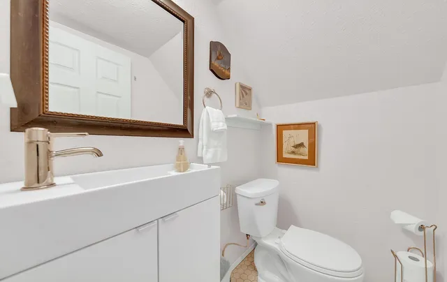 a view of house with a big yard and large trees