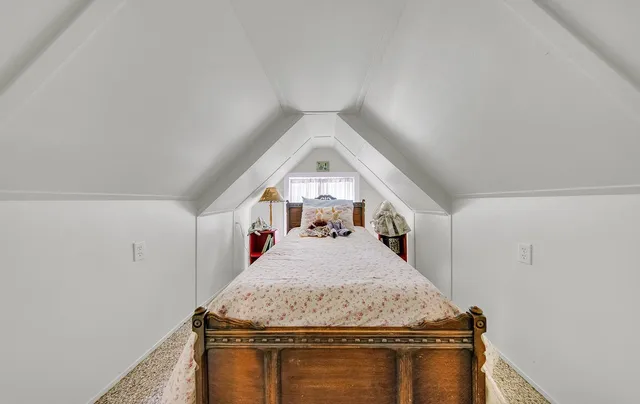 a backyard of a house with table and chairs plants and large tree