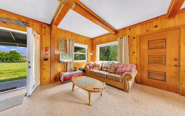 a view of a dining room with furniture a chandelier and a window