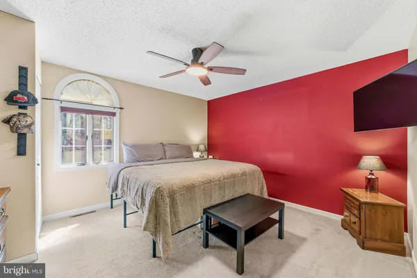 a spacious bedroom with a bed and a chandelier