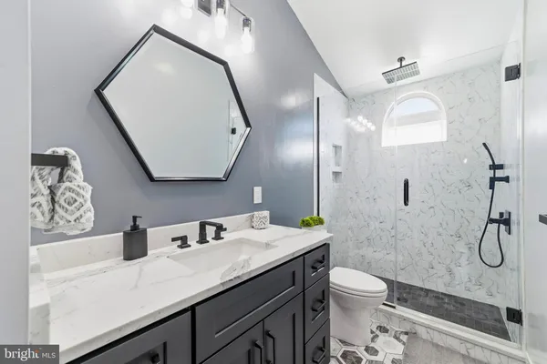 a bathroom with a granite countertop sink mirror toilet and shower