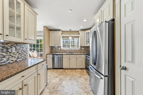 a kitchen with stainless steel appliances granite countertop a refrigerator and a sink