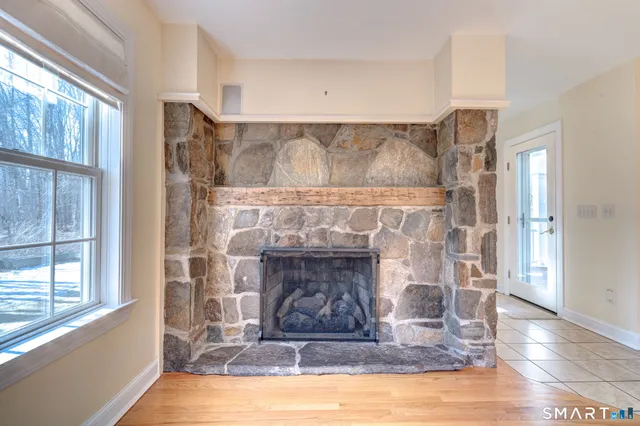 a living room with a fireplace windows and a wooden floor