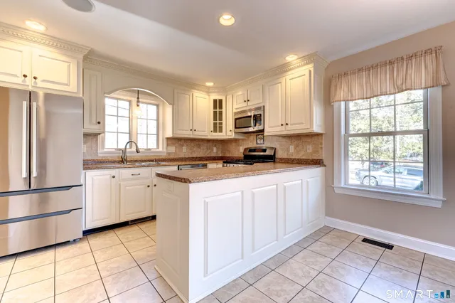 a kitchen with granite countertop white cabinets and white appliances