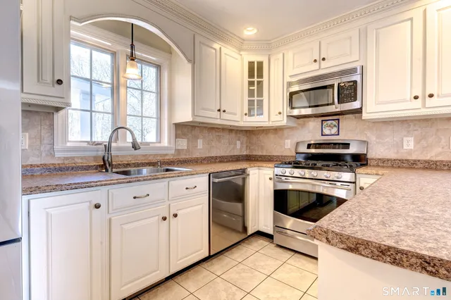 a kitchen with granite countertop white cabinets and white appliances