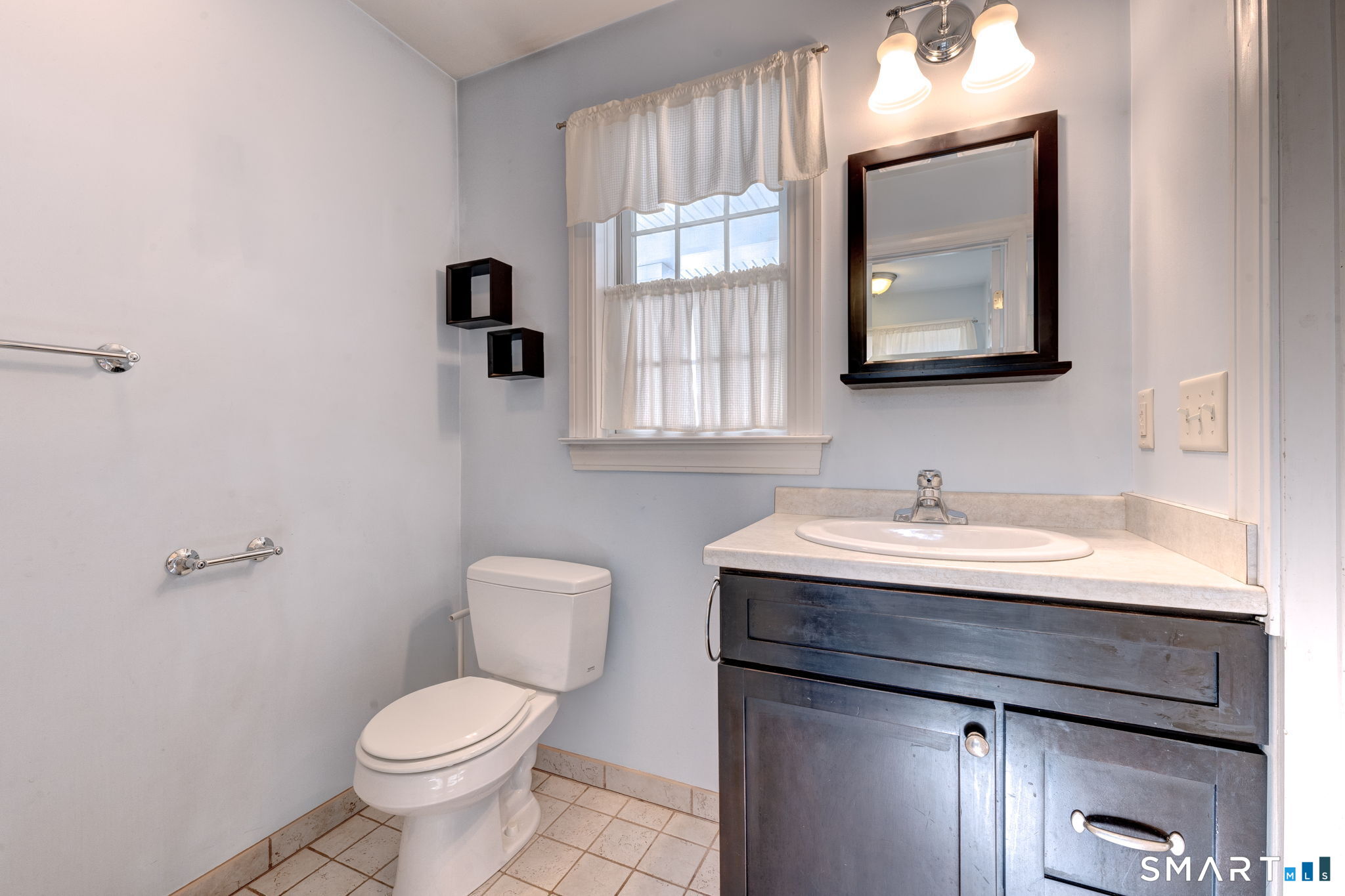 353 Warrenville Road Mansfield, CT 06250 - Photo 23 of 40 a bathroom with a toilet sink a mirror and window