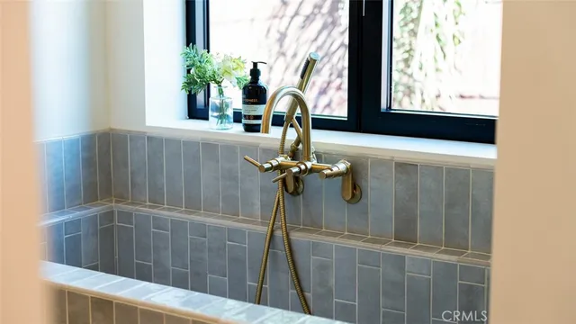 a living room with furniture a potted plant and a large window