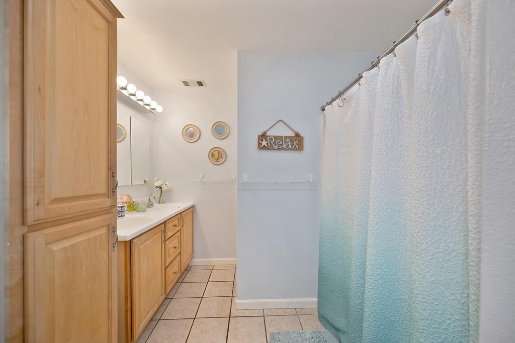 3641 Catlett Road Pleasant Grove, CA 95668 - Photo 14 of 29 a bathroom with a sink a mirror and a shower curtain
