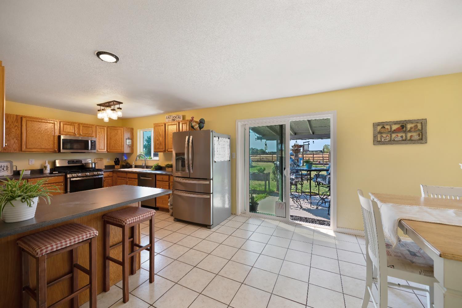 3641 Catlett Road Pleasant Grove, CA 95668 - Photo 16 of 29 a kitchen with granite countertop a refrigerator and a stove top oven