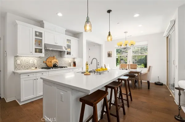 a kitchen with a table chairs stove and white cabinets