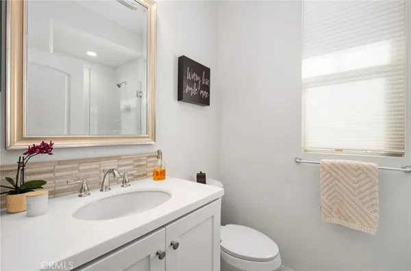 a bathroom with a sink vanity mirror and toilet