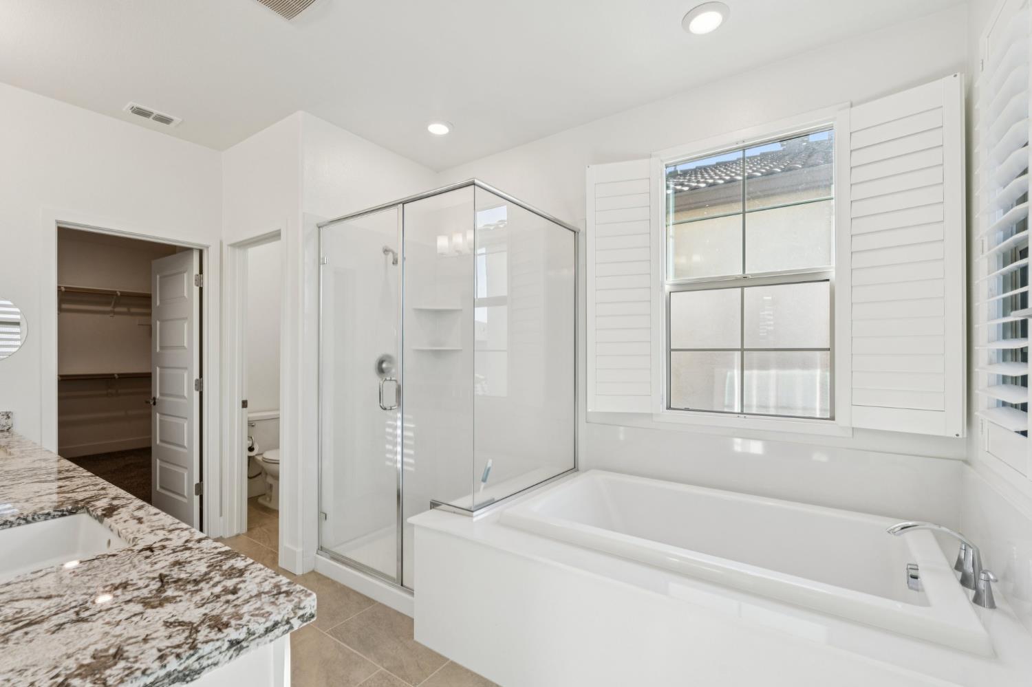 10458 Oboe Way Elk Grove, CA 95757 - Photo 23 of 38 a bathroom with a bathtub and a shower