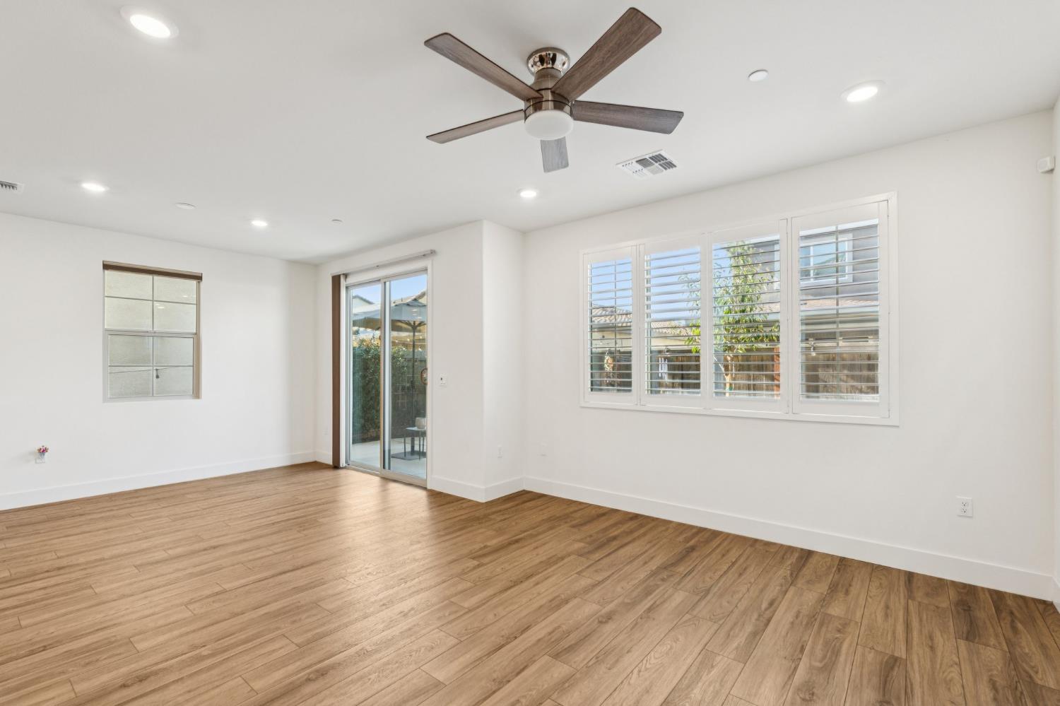 10458 Oboe Way Elk Grove, CA 95757 - Photo 9 of 38 a view of an empty room with wooden floor and a window