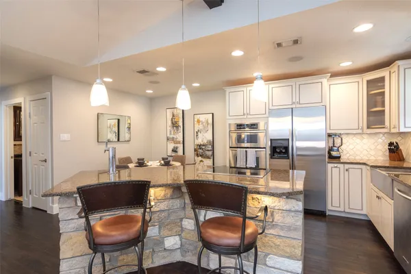 a kitchen with stainless steel appliances kitchen island granite countertop a sink and cabinets