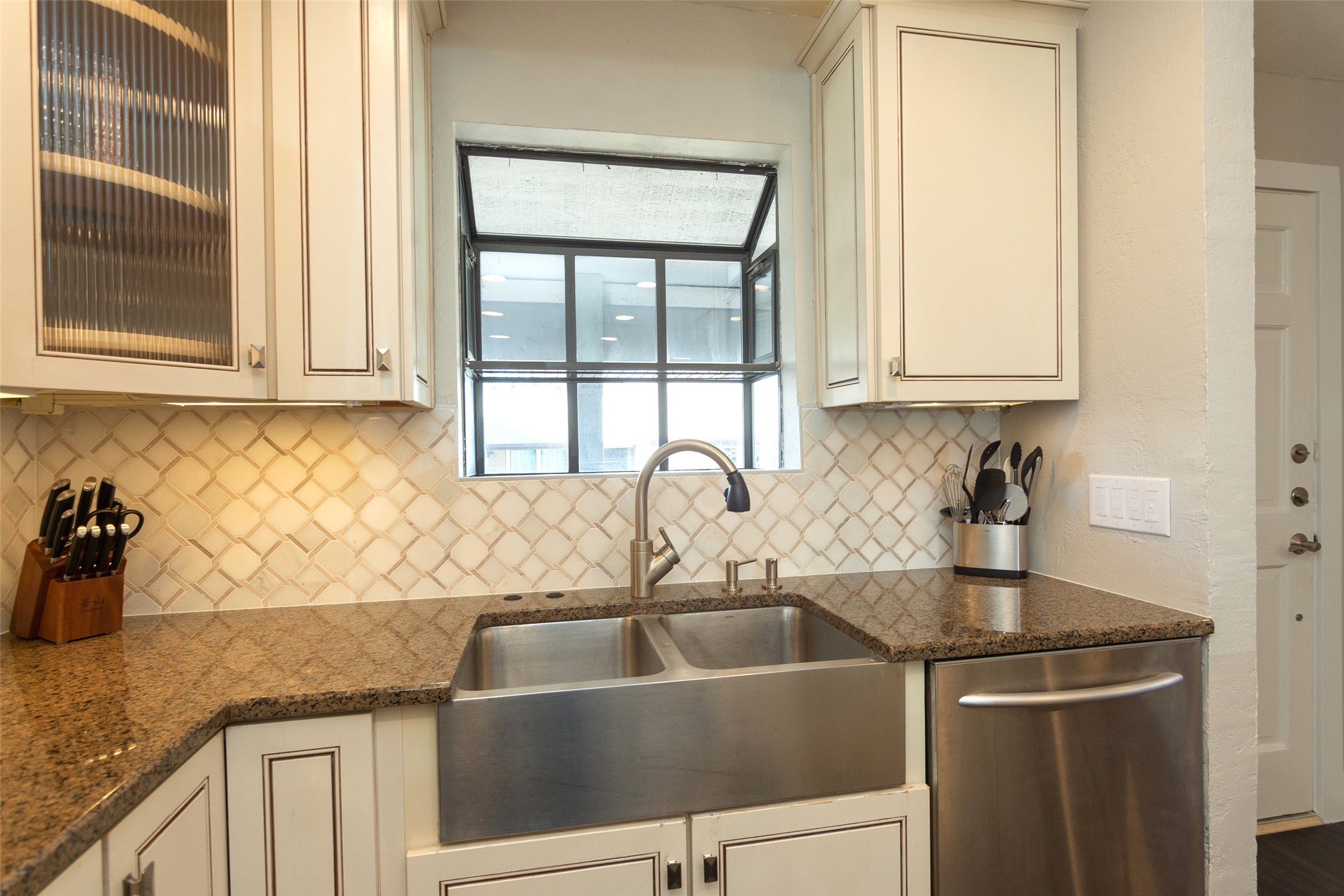 2410 Enfield Road, Unit 10 Austin, TX 78703 - Photo 16 of 40 a kitchen with granite countertop a sink and a window