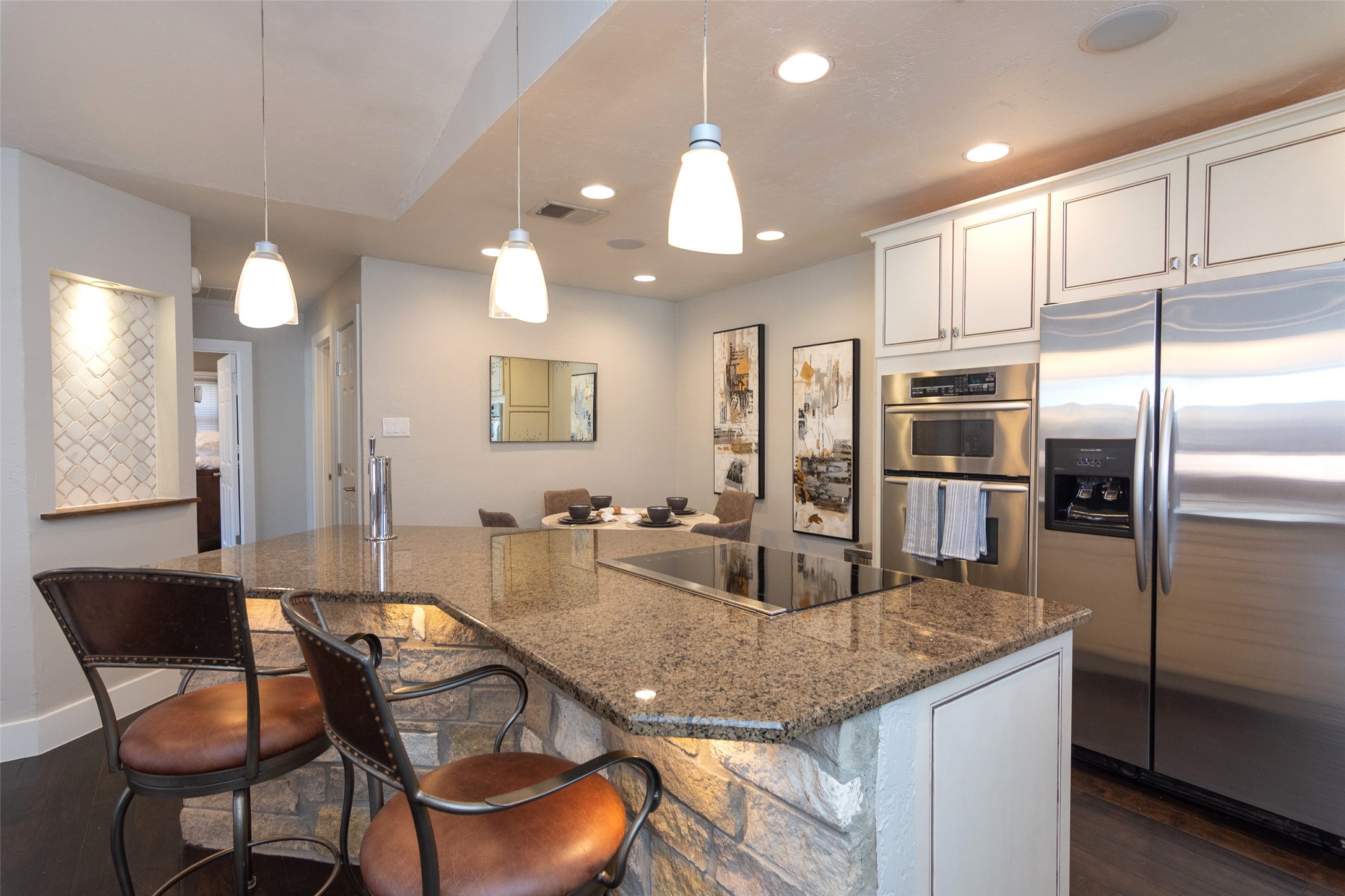 2410 Enfield Road, Unit 10 Austin, TX 78703 - Photo 19 of 40 a kitchen with granite countertop a table chairs microwave and refrigerator