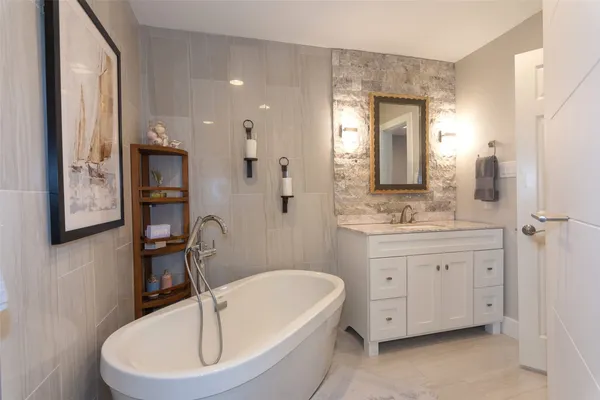 a bathroom with a double vanity sink a mirror and a bathtub