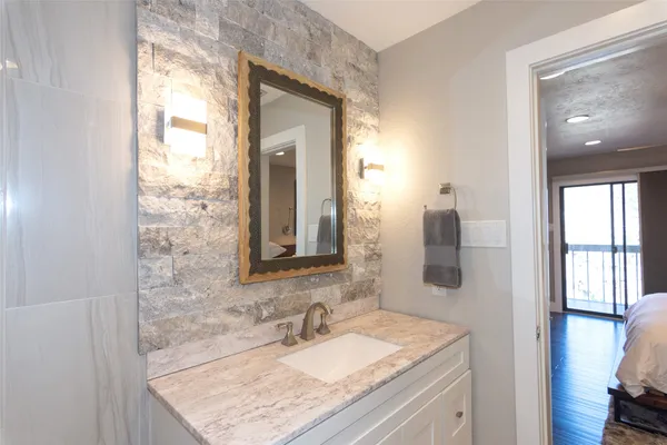 a bathroom with a granite countertop sink and a mirror