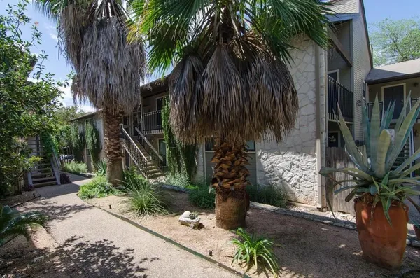 a couple of palm trees in front of yellow house