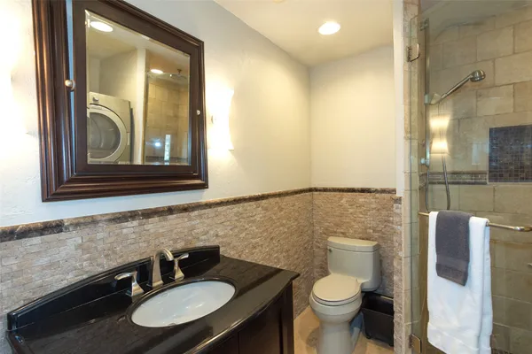 a bathroom with a toilet sink and mirror