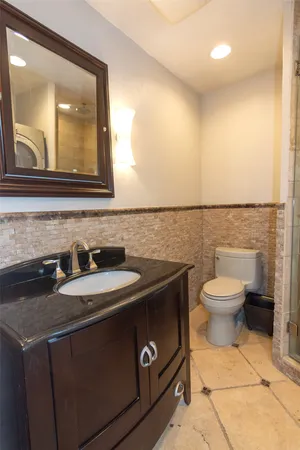 a bathroom with a toilet a sink and a mirror