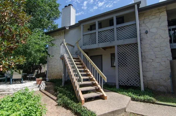 a view of house with entryway and wooden fence